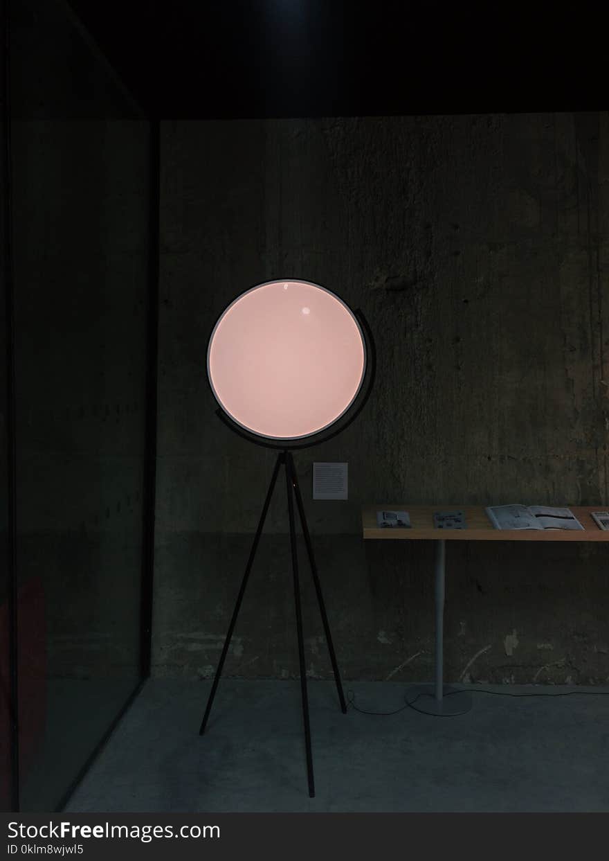 Round Pedestal Mirror Beside Brown Table