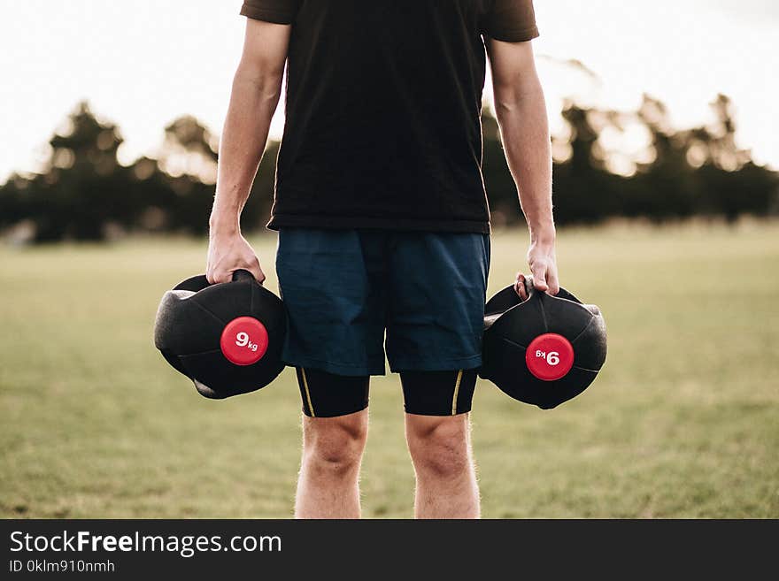 Person Holding Black Dumbbells