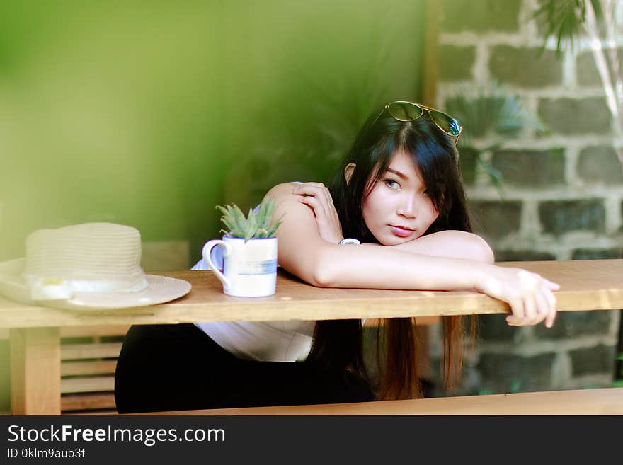 Woman Wearing White Shirt Sitting Near Table