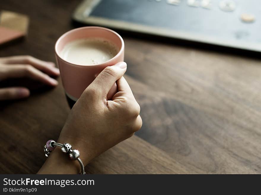 Person Holding Pink Ceramic Mug