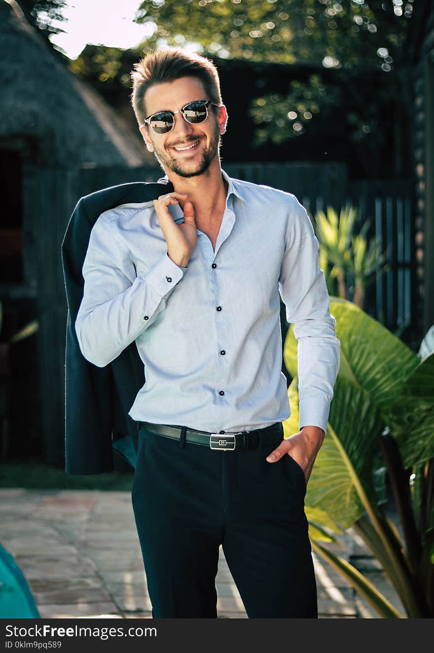 Man in White Dress Shirt Holding Suit Jacket