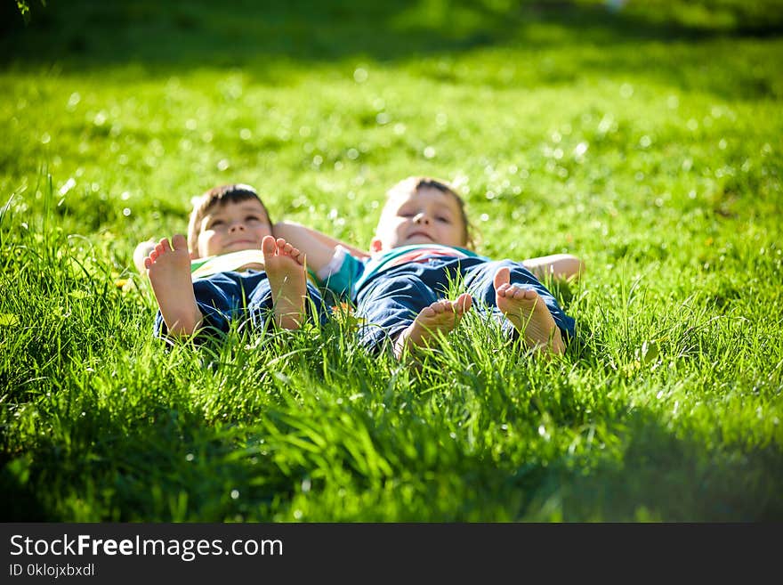 Children laying on grass. Family picnic in spring park. Image of several legs lying on the grass and resting. Relaxation happy childhood friendship concept.