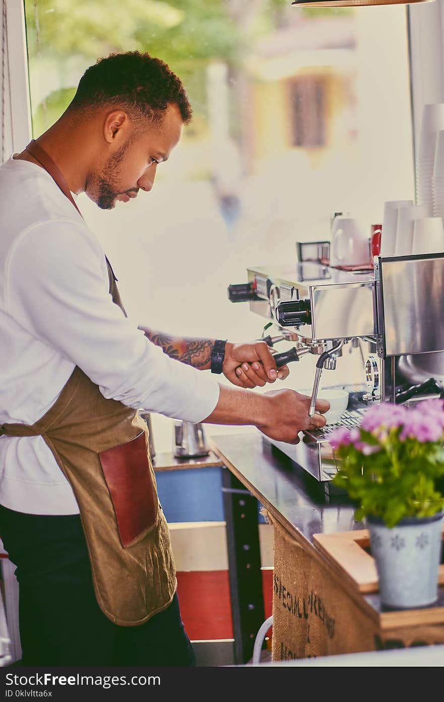 Black bearded coffee seller pouring coffee.