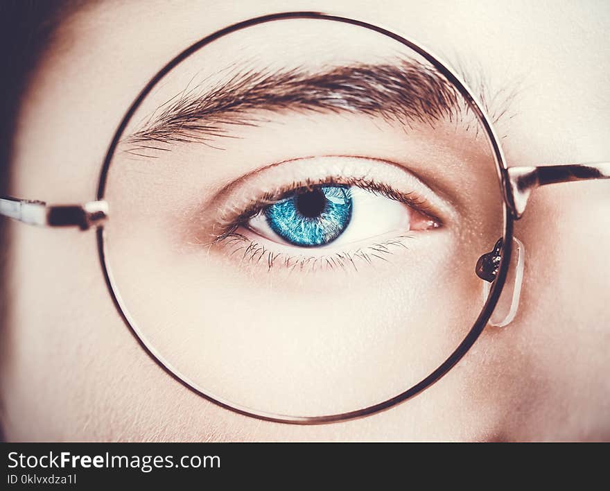 Portrait of a boy wearing eyeglasses blue eyes close, macro studio shot