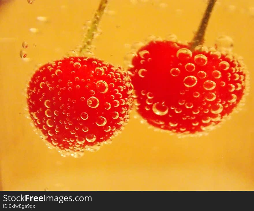 Red cherry in water and bubbles