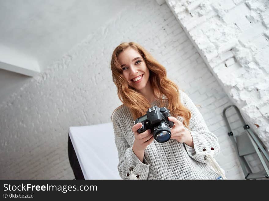 Cheerful young photographer with digicam laughing during photo session. Cheerful young photographer with digicam laughing during photo session