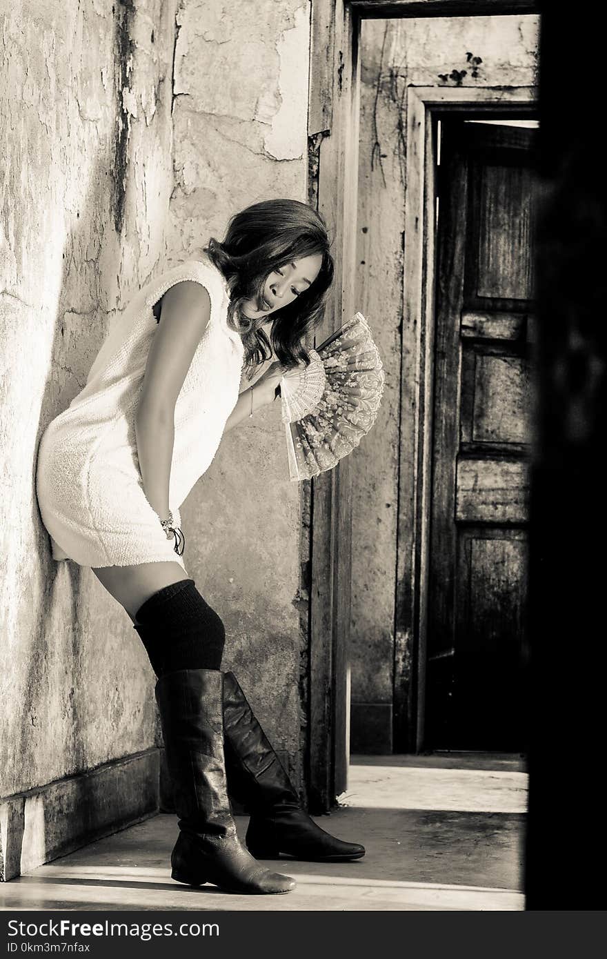 Grayscale Photography of Woman Leaning on Wall