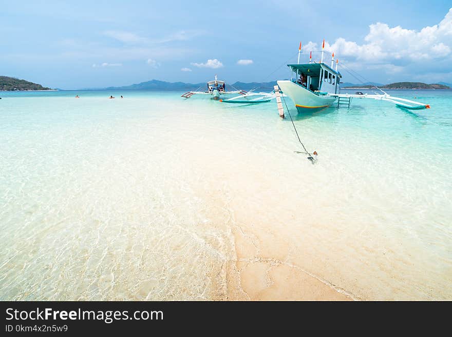 Tropical sand beach with tourists and boats on the Bulog Dos island, Palawan, Philippines