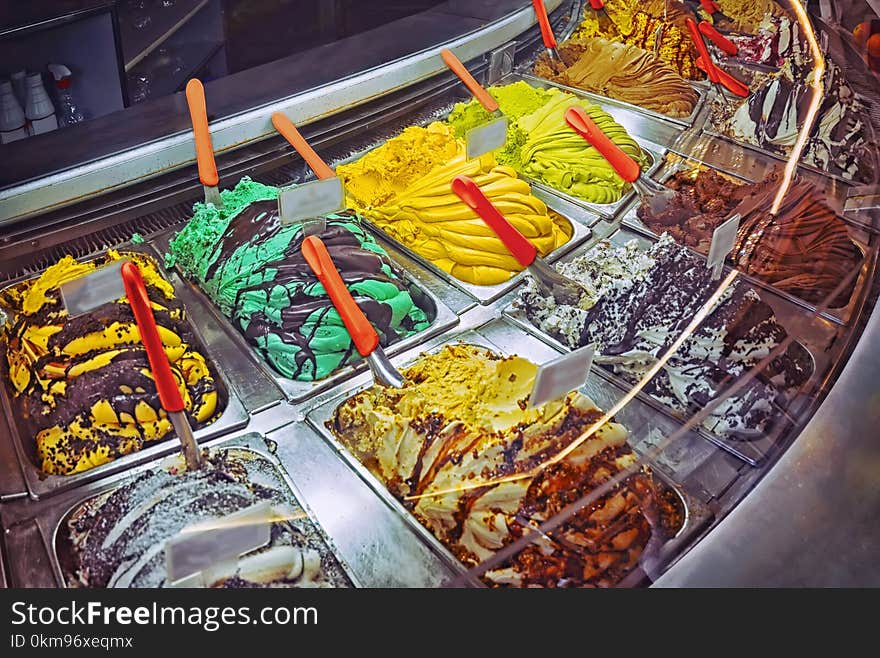 Many boxes of typical classic italian gourmet gelato ice cream display in shop