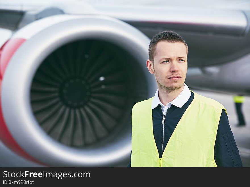 Member ground crew worker at the airport checking airplane before flight. Member ground crew worker at the airport checking airplane before flight.