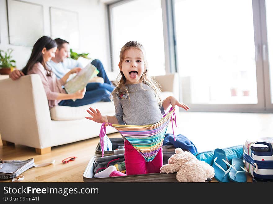 Young happy family with a small child packing for holiday at home. Young happy family with a small child packing for holiday at home.