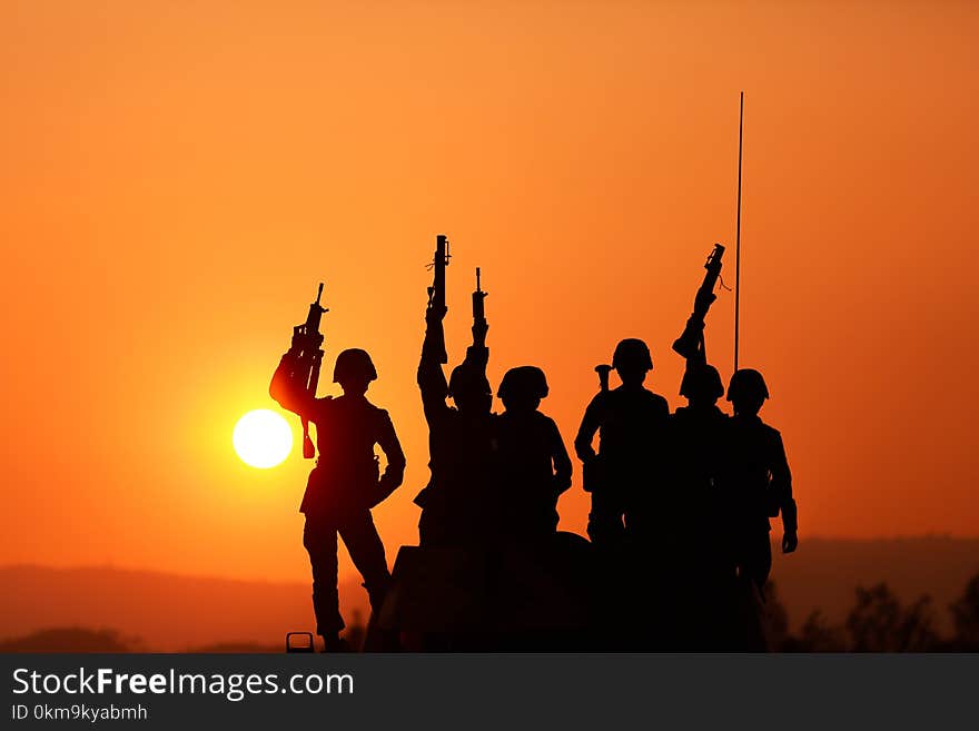 Soldiers silhouettes against a sunset.