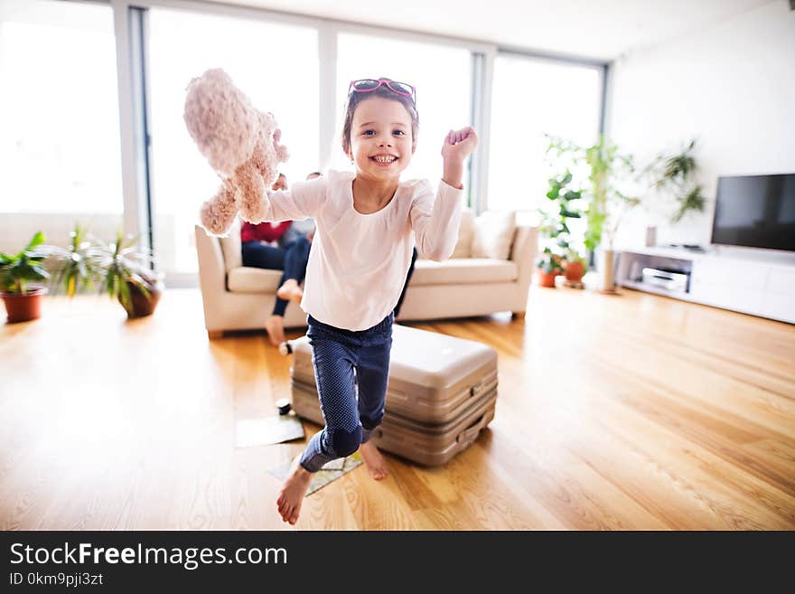 Young happy child with parents in the background packing for holidays.