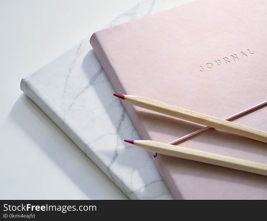 Closeup Photo of Journal Book and Pencils