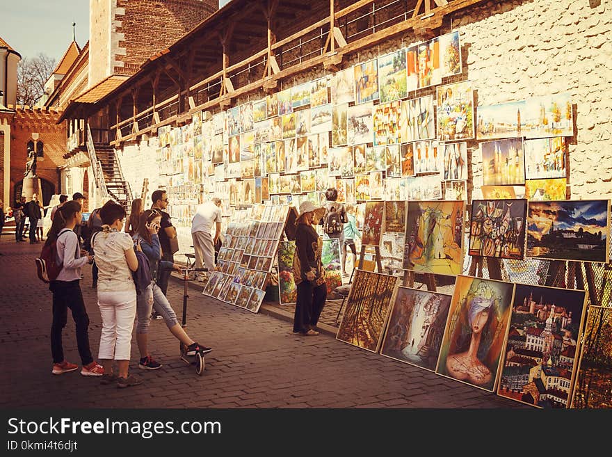 People Looking at Assorted-type Paintings