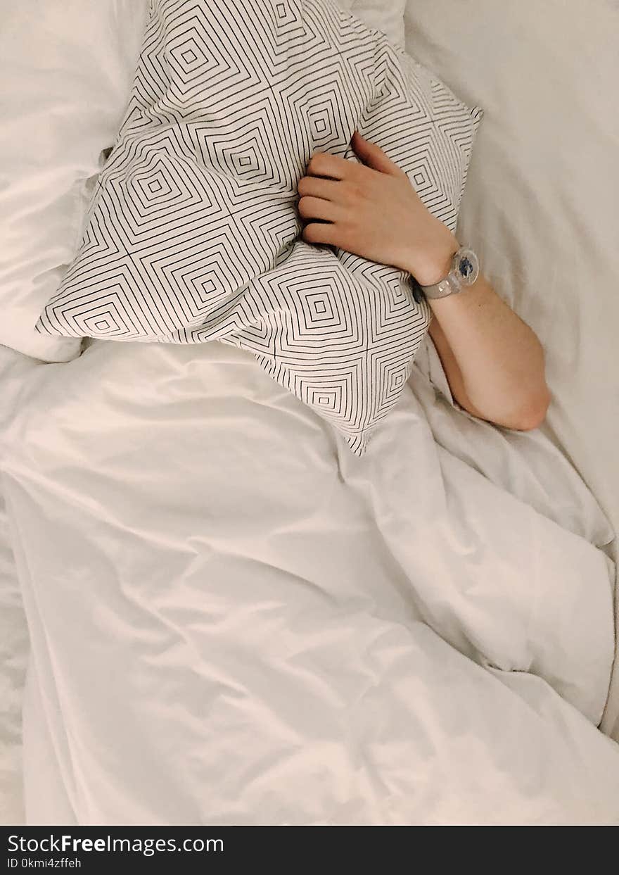 Person Holding Gray and White Throw Pillow