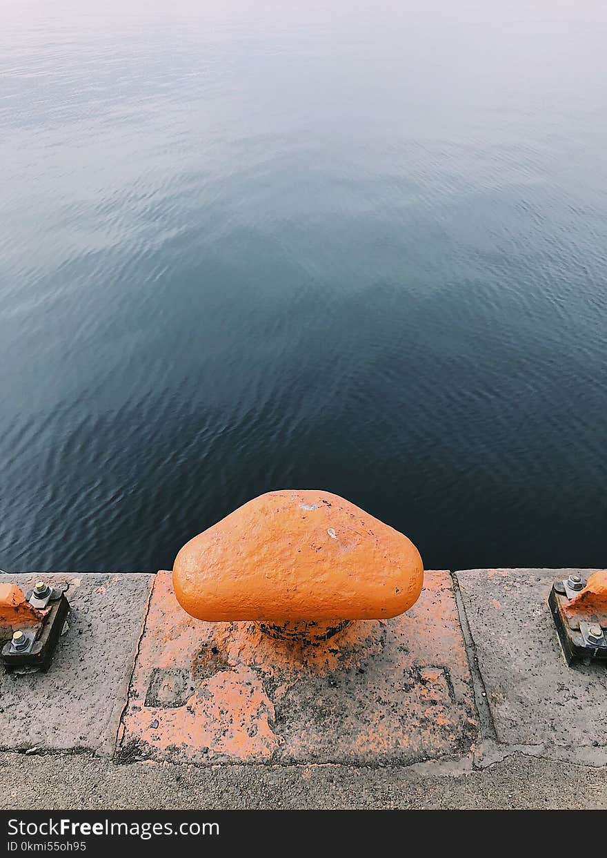 Orange and Gray Concrete Rope Tie Holder at Daytime