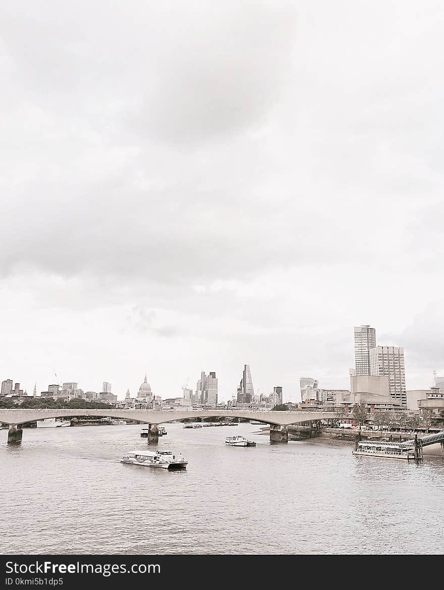 Grayscale Photo of Bridge Near White Boat