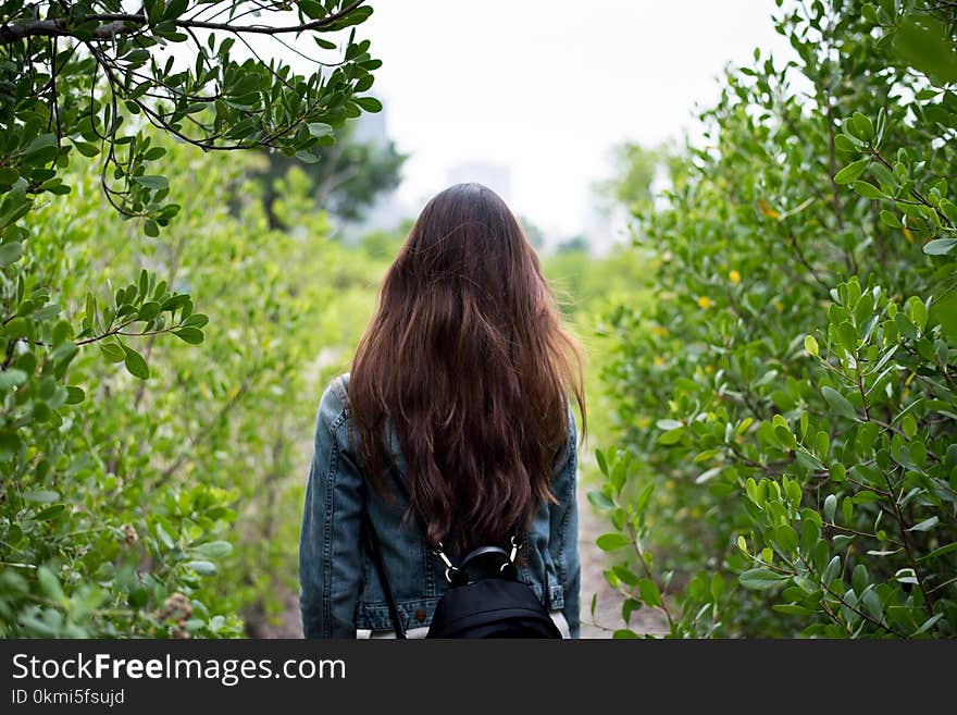 Woman in Gray Denim Jacket in the Middle of Bushes