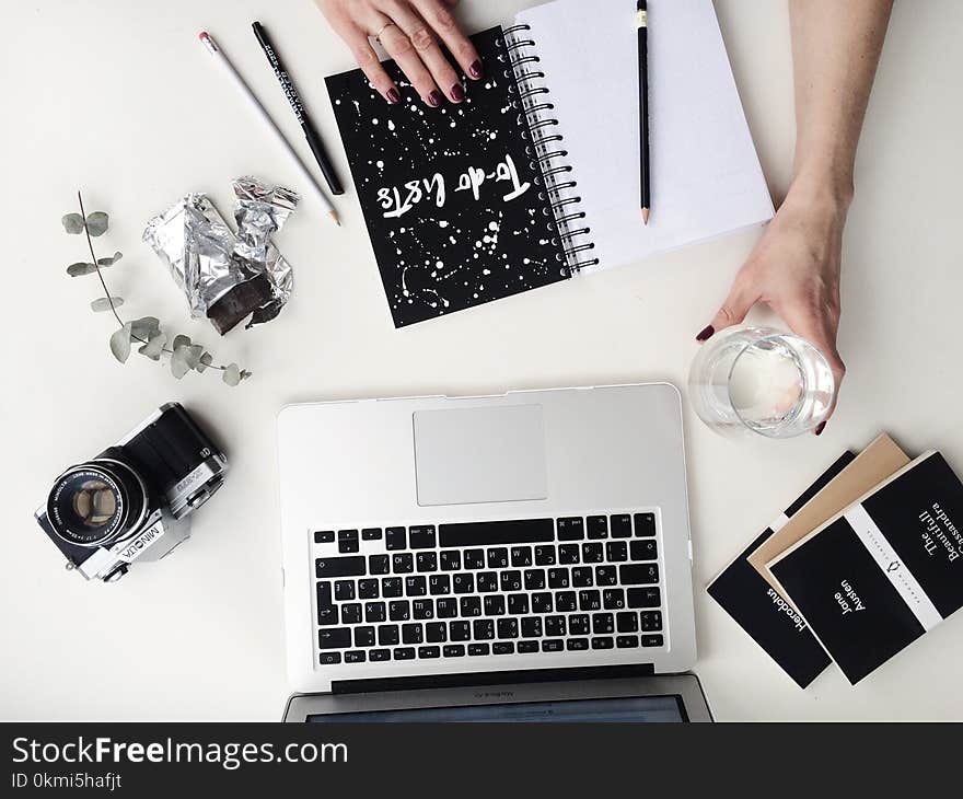 Person Hand Holding Drinking Glass on White Table