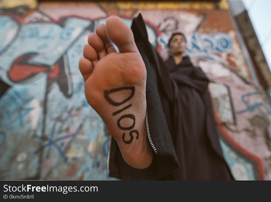 Person Wearing Black Robe With Sign on Foot