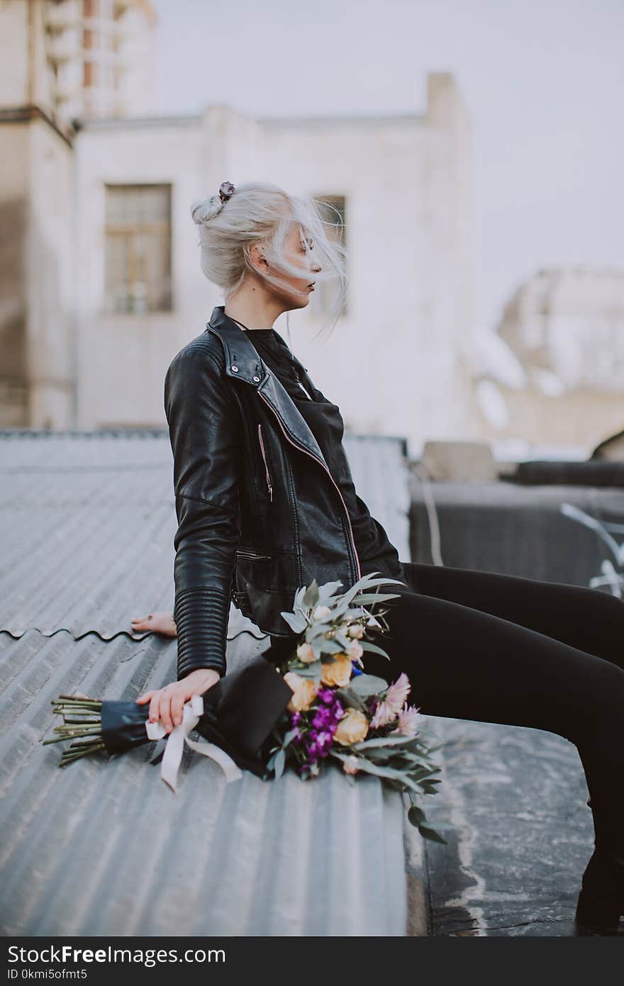 Woman Wearing Black Leather Full-zip Jacket Sitting on Galvanized Roof