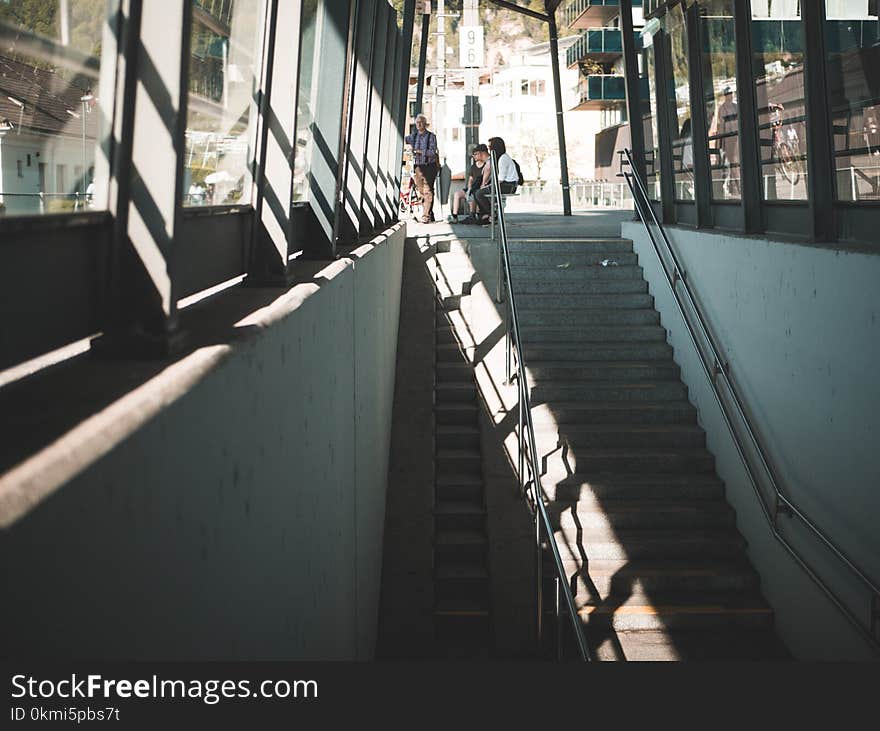 People Sitting on Bench Near Staircase