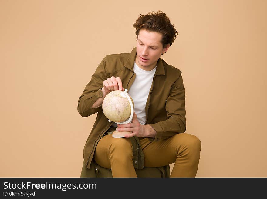 Man Sitting Holding White Desk Globe