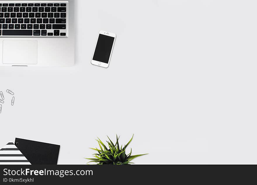 White Smartphone Beside Silver Laptop Computer