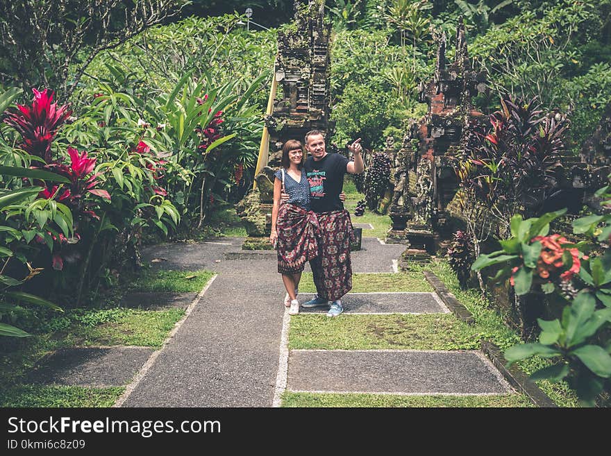 Woman and Man Standing Together and Looking on Flower Garden