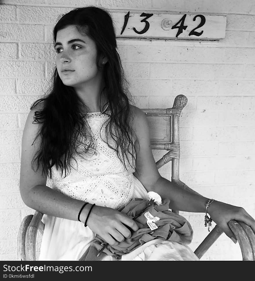 Grayscale Photo of Girl Sitting on Armchair