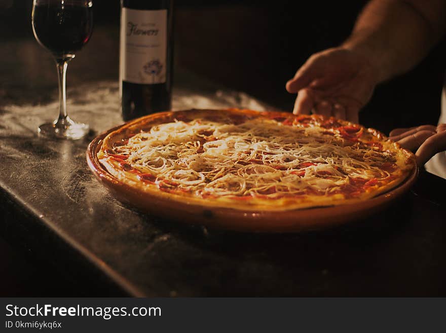 Person Holding Pepperoni Pizza on Tray