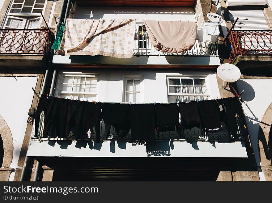 Close Up Photo of Black Clothes Hanged Outside Window