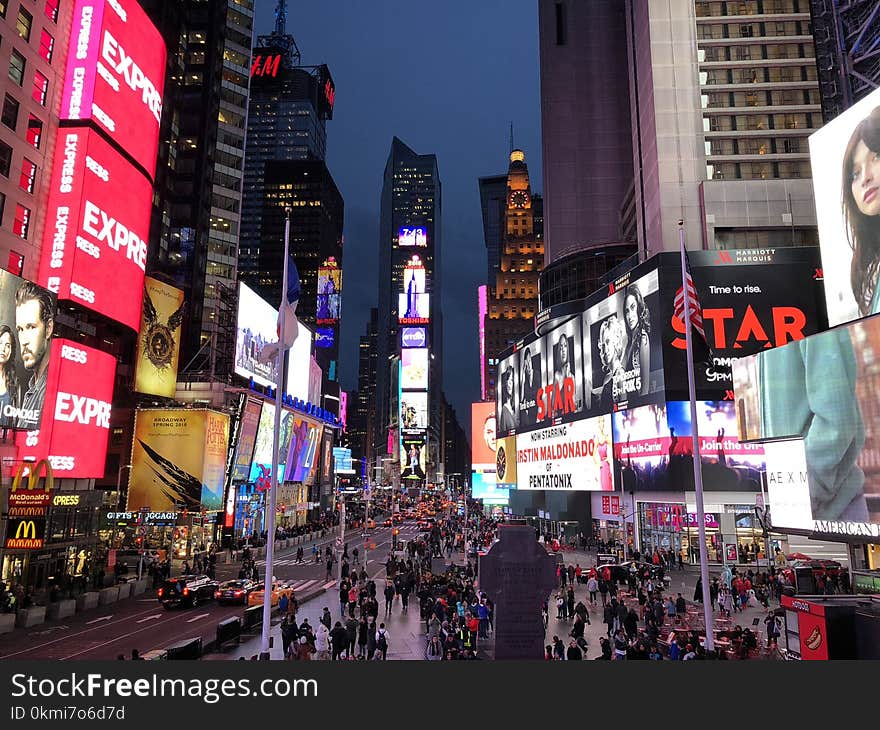 Crowd Walking Between Lighted Buildings during Nighttime