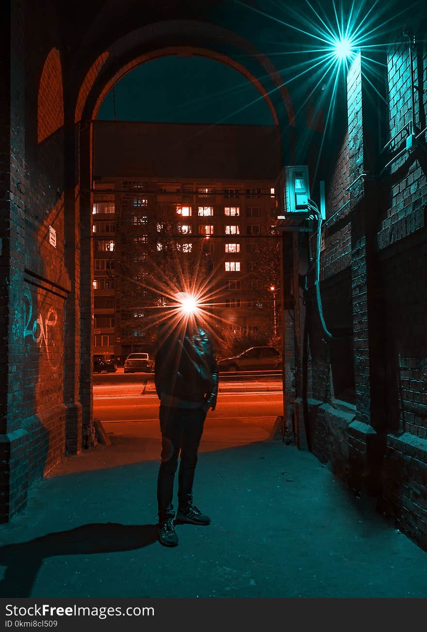 Photo of Man in Jacket Standing in Alley