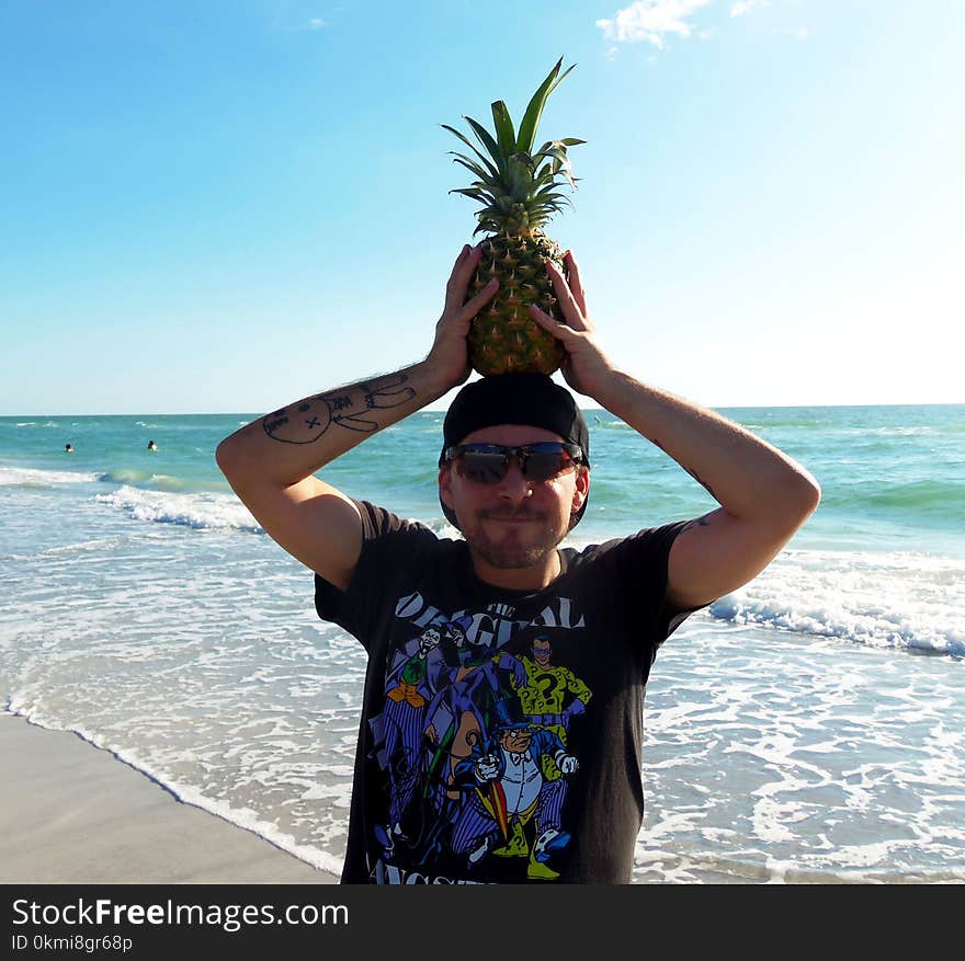 Photography of a Man Holding Pineapple