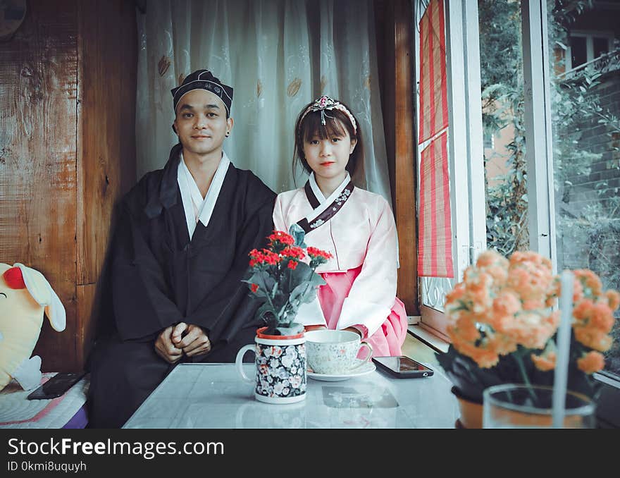 Man and Woman in Front of Red Flowers