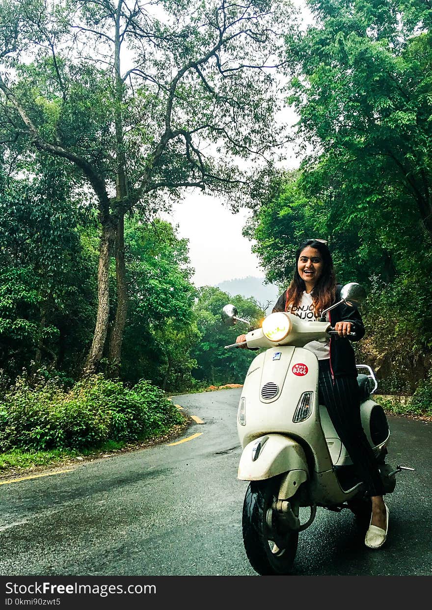 Woman Wearing White Crew-neck Shirt on Motor Scooter