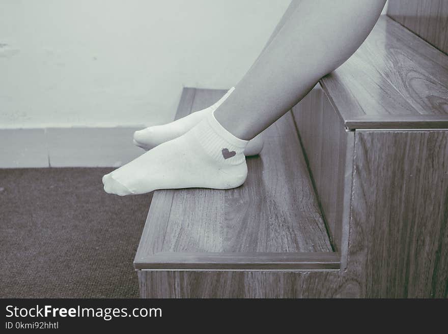 Person Wearing Pair of Foot Socks Sitting on Staircase