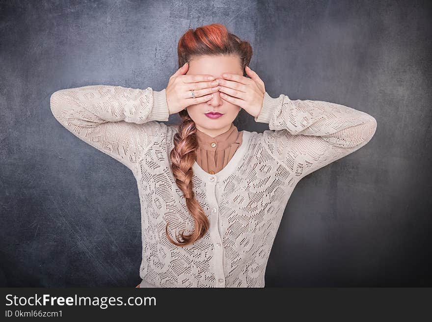 Stylish woman covering her eyes with hands on the chalkboard blackboard background