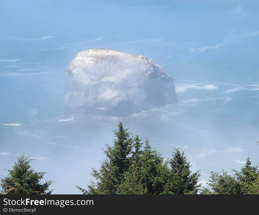 Rock Island Off the Foggy Shore of Pacific Northwest