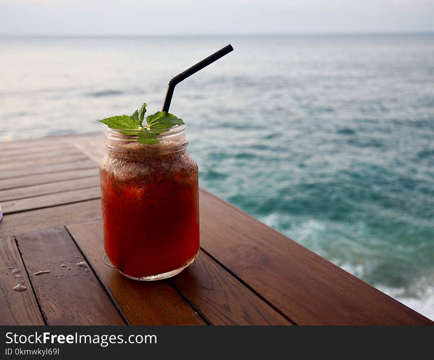 Photo of Orange Beverage in Clear Glass Mason Jar