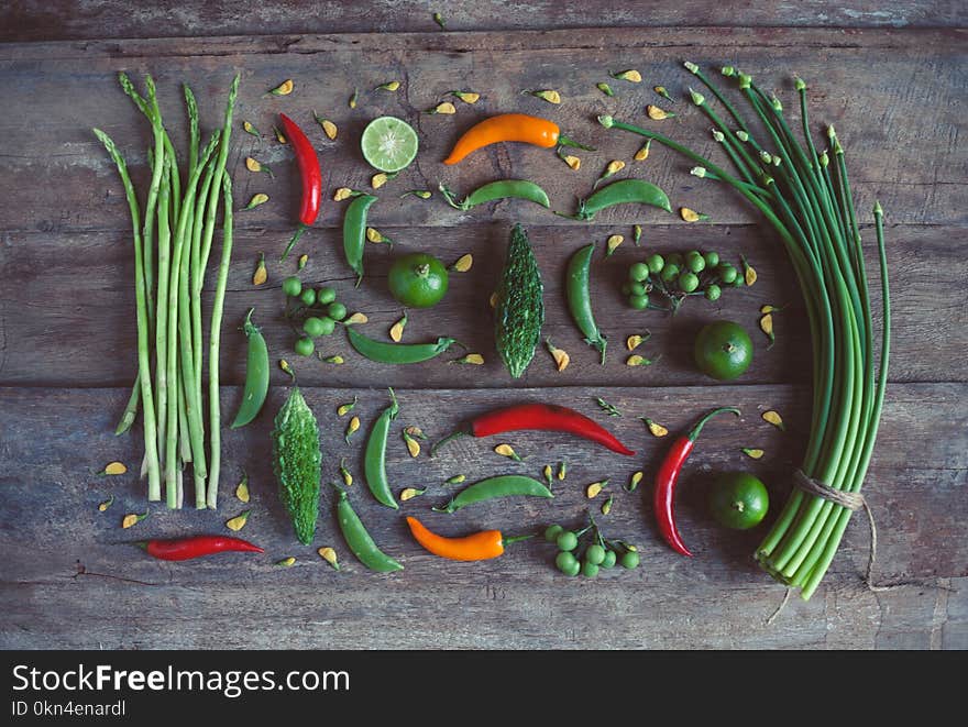 Different organic green, orange and red vegetables, Asparagus, pepper, lime and other veggies on wooden background. Different organic green, orange and red vegetables, Asparagus, pepper, lime and other veggies on wooden background