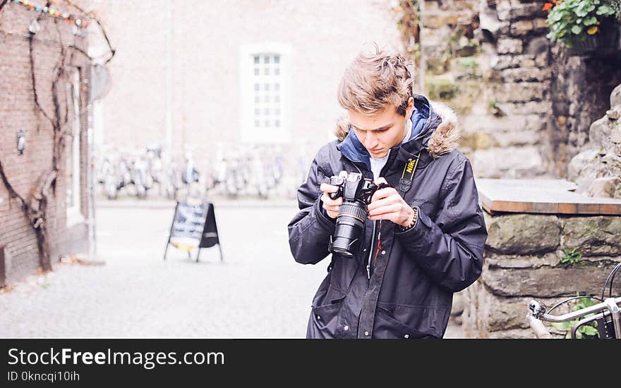 Man Holding Black Dslr Camera