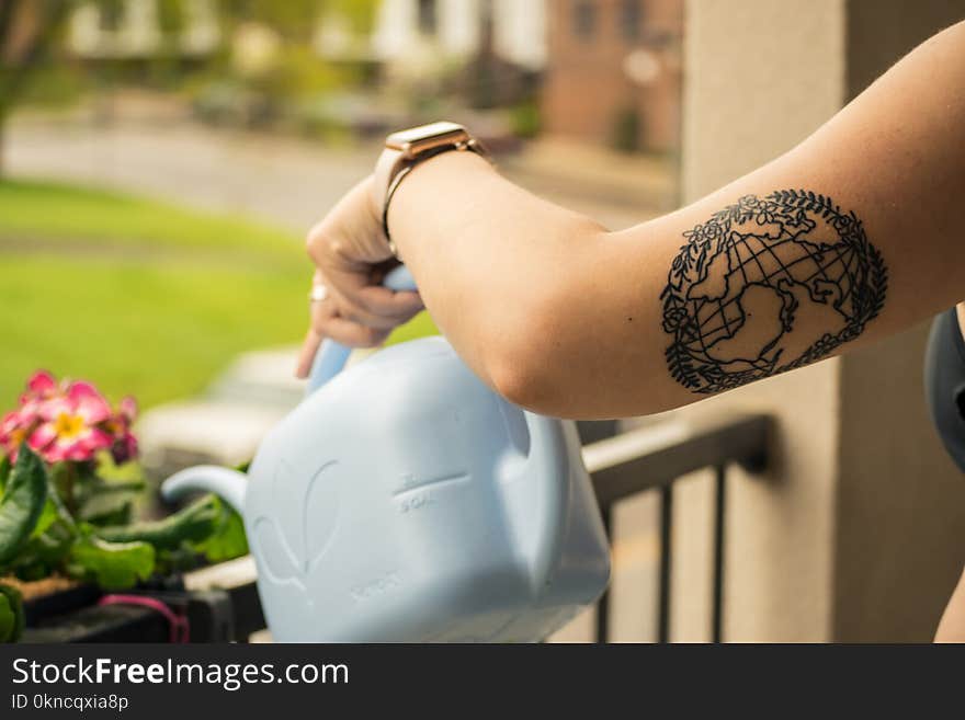 Person Holding Gray Plastic Watering Can