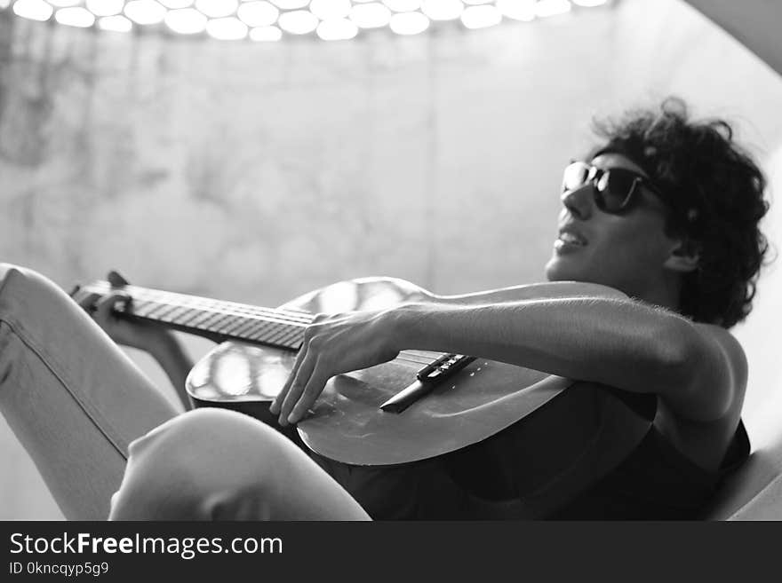 Grayscale Photo of Man Playing Guitar