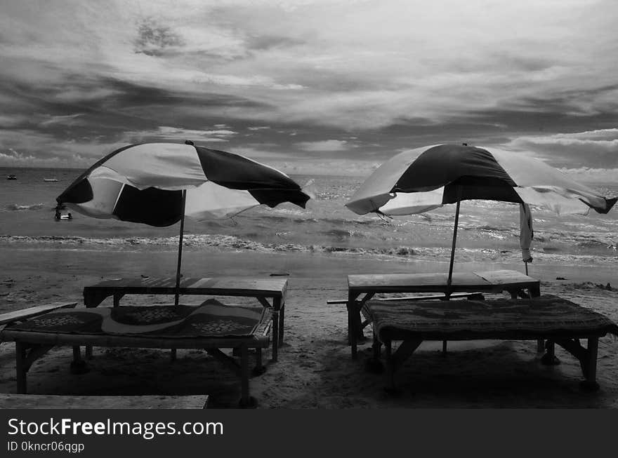 Grayscale Photography of Two Picnic Tables on Seashore