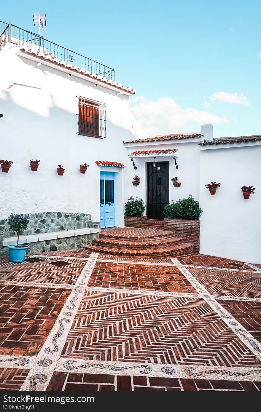 White Concrete House With Brown Tiled Yard