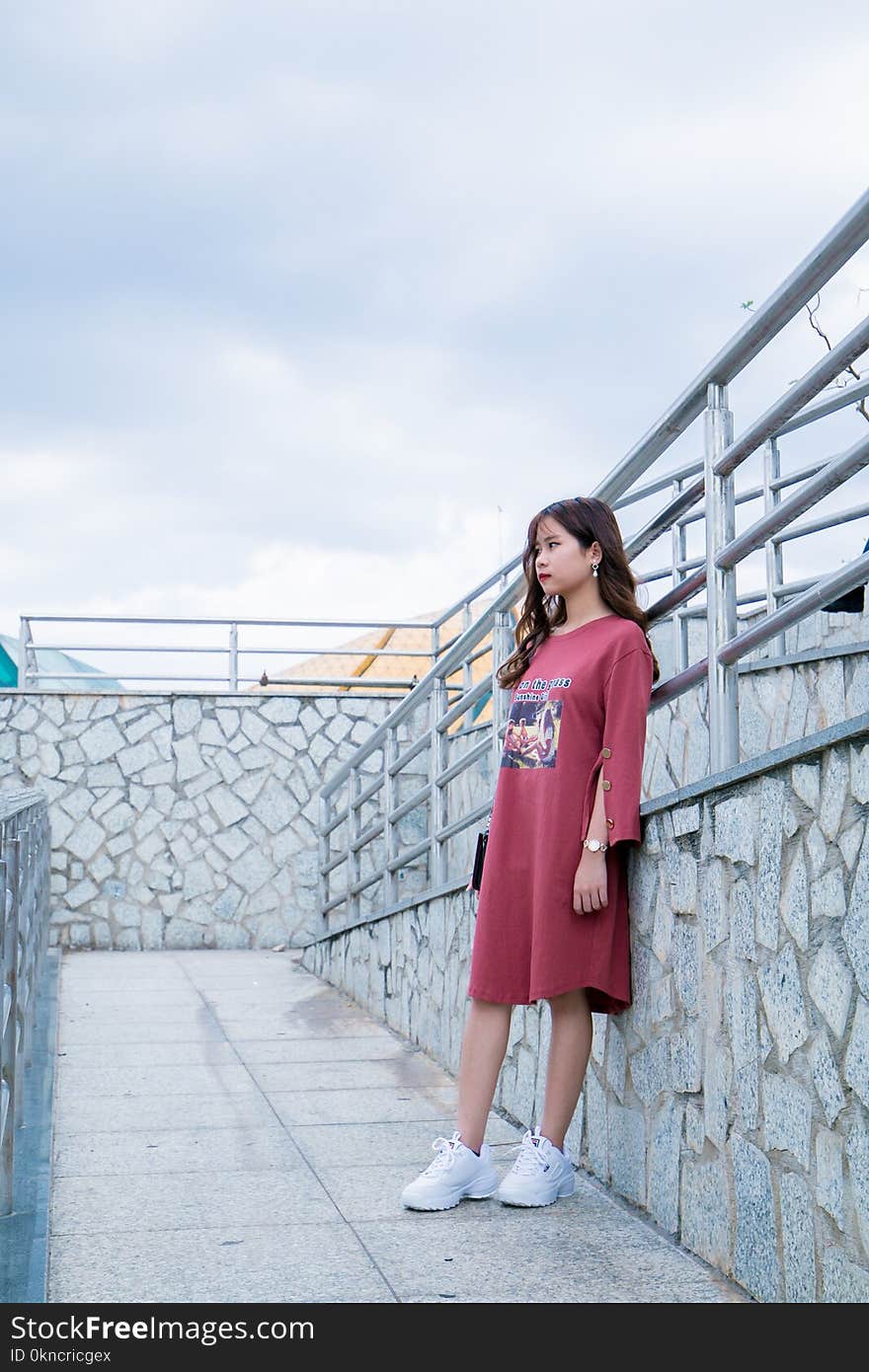 Woman Wearing Red Long-sleeved Shirt Dress Stands Next to Gray Metal Handrails