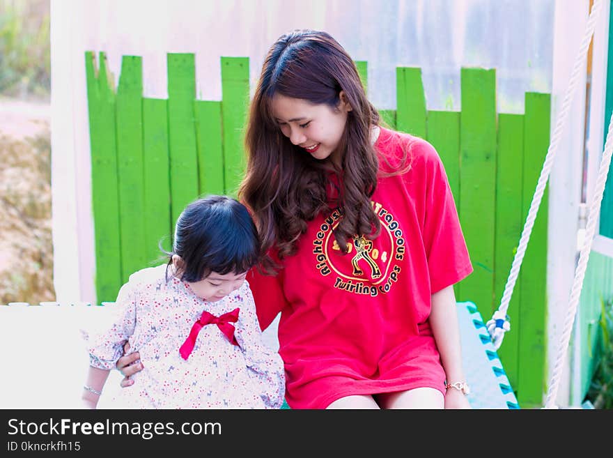 Woman in Red T-shirt Sitting Beside Girl